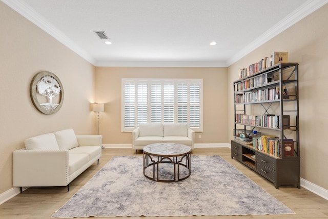 living room featuring visible vents, crown molding, and light wood finished floors