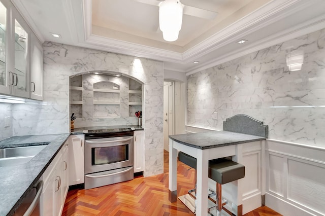 kitchen with white cabinetry, appliances with stainless steel finishes, glass insert cabinets, and ornamental molding