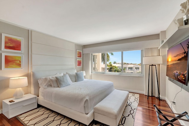 bedroom featuring wood finished floors and baseboards