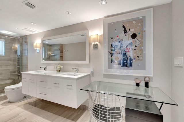 bathroom featuring visible vents, wood finished floors, a sink, and a bath