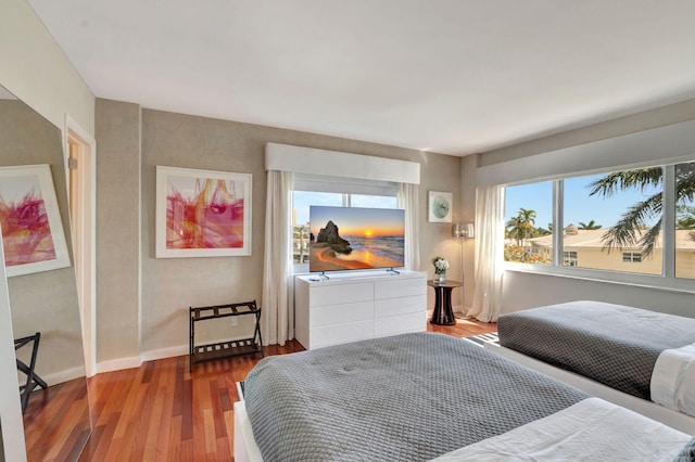 bedroom with baseboards and wood finished floors