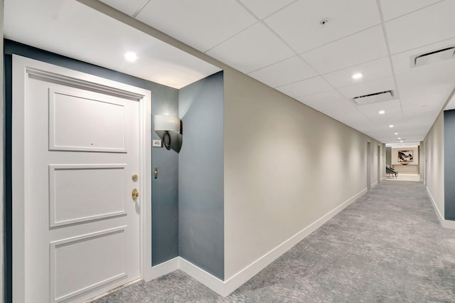 hall with recessed lighting, a drop ceiling, visible vents, and baseboards