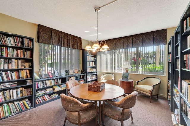 carpeted dining room featuring a textured ceiling and an inviting chandelier