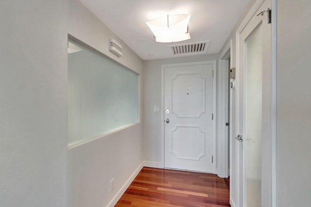 doorway to outside featuring baseboards, visible vents, and wood finished floors