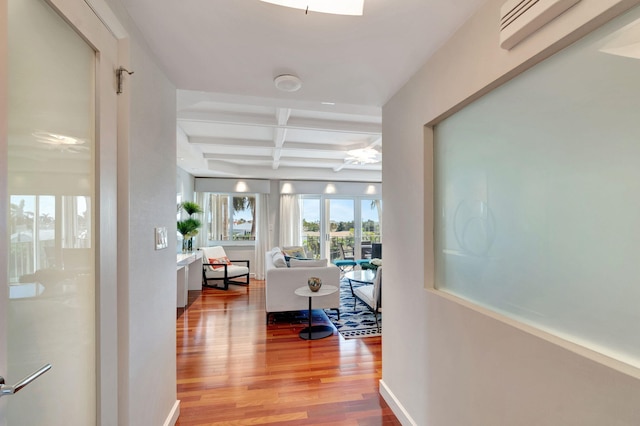 corridor with beam ceiling, baseboards, coffered ceiling, and wood finished floors