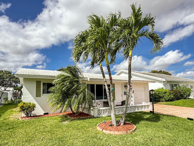 ranch-style home with an attached garage, a front lawn, decorative driveway, and stucco siding