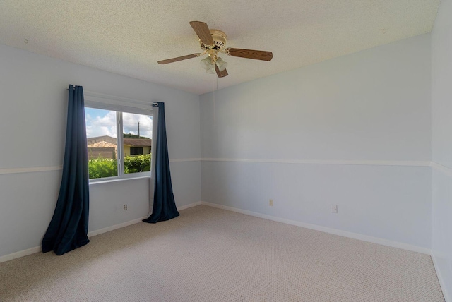 empty room featuring carpet floors, a textured ceiling, baseboards, and a ceiling fan