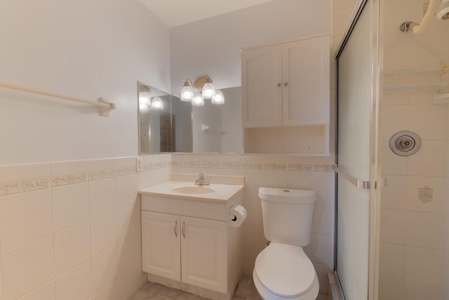 bathroom with toilet, a stall shower, vanity, and tile walls