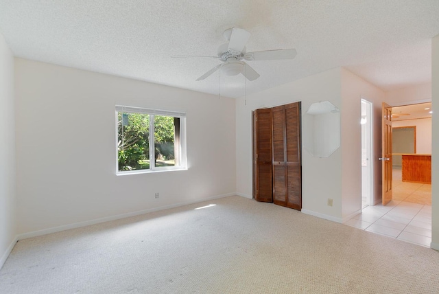 unfurnished bedroom featuring light carpet, a closet, and a textured ceiling