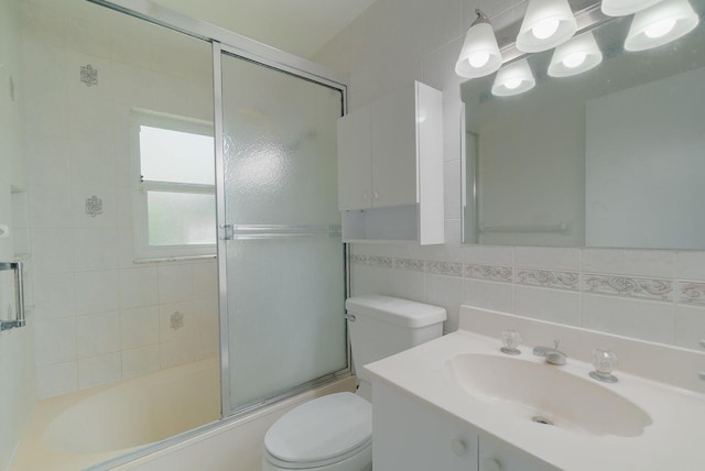 full bathroom with toilet, shower / bath combination with glass door, vanity, tile walls, and decorative backsplash