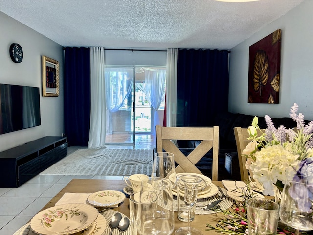 tiled dining room featuring a textured ceiling