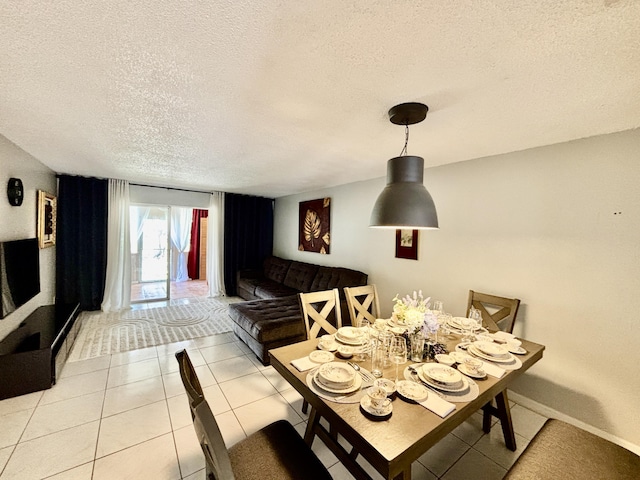 dining room featuring baseboards, a textured ceiling, and light tile patterned flooring