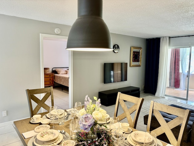 dining area featuring a textured ceiling and light tile patterned floors