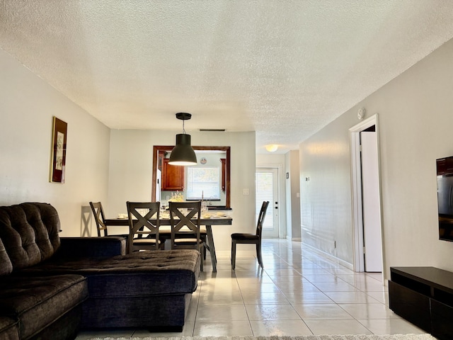 living room with a textured ceiling and light tile patterned flooring