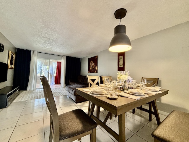 dining area featuring light tile patterned floors and a textured ceiling