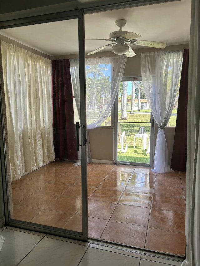 doorway featuring a ceiling fan and tile patterned floors