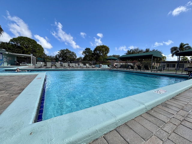 community pool featuring fence and a patio