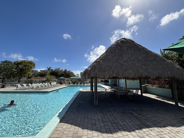 pool featuring fence, a patio, and a gazebo