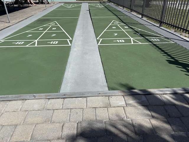 view of home's community with shuffleboard and fence