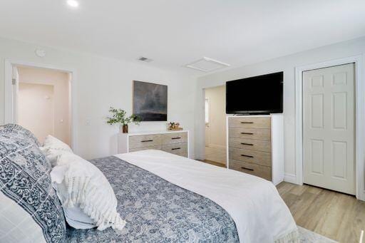 bedroom featuring visible vents, attic access, and light wood-style floors