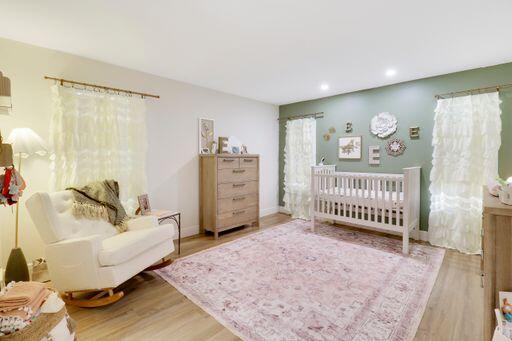 bedroom with baseboards, wood finished floors, and recessed lighting