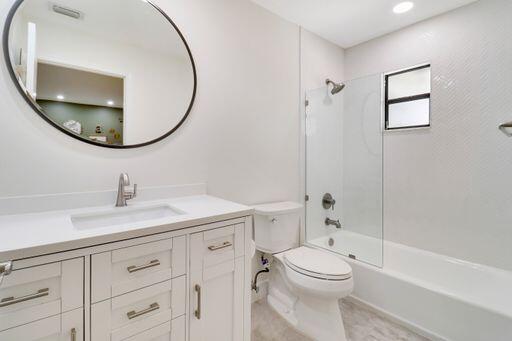 bathroom with toilet, vanity, and bathing tub / shower combination