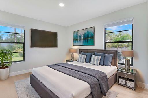 bedroom featuring multiple windows, recessed lighting, light wood-style flooring, and baseboards