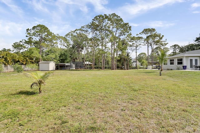 view of yard with an outbuilding, fence, and a shed