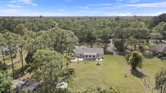 bird's eye view with a wooded view