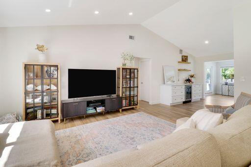 living area with light wood-style floors, recessed lighting, and beverage cooler