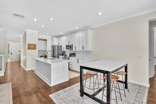 kitchen featuring white cabinetry, visible vents, light wood-style floors, appliances with stainless steel finishes, and backsplash