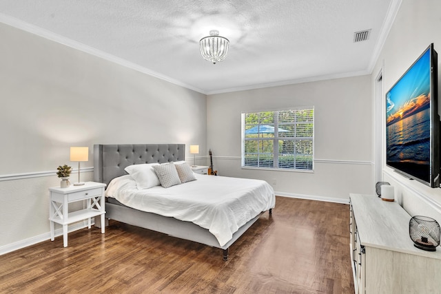 bedroom with crown molding, visible vents, and wood finished floors