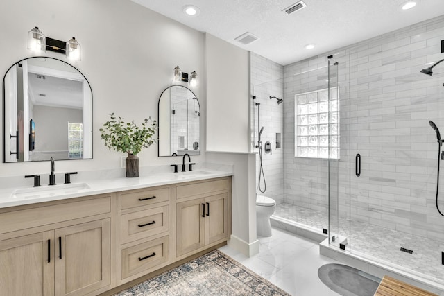 bathroom with marble finish floor, a sink, visible vents, and a shower stall