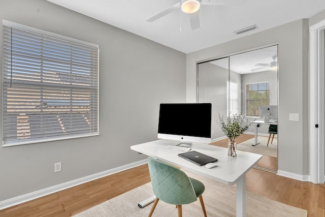 office featuring baseboards, visible vents, and wood finished floors