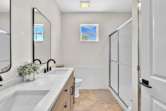 bathroom featuring a healthy amount of sunlight, a shower stall, and a sink