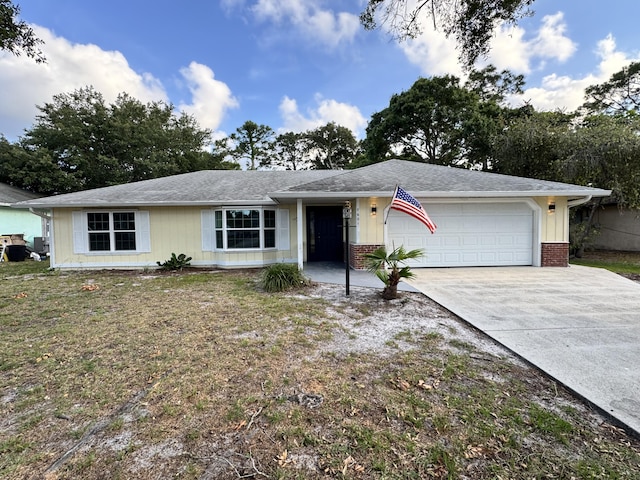 ranch-style house with a front lawn, driveway, an attached garage, and brick siding