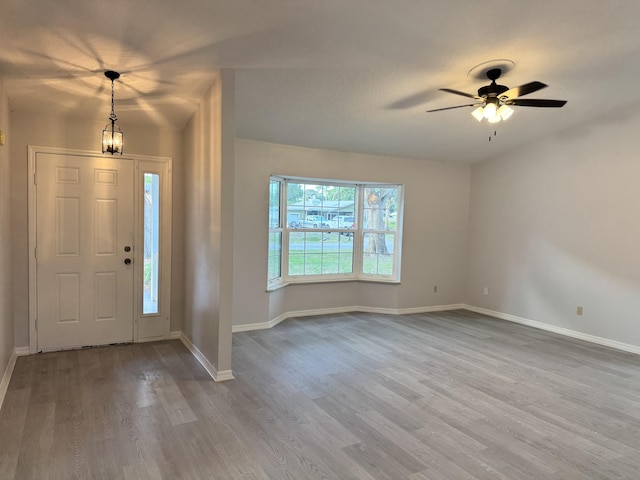 foyer featuring wood finished floors, ceiling fan, and baseboards