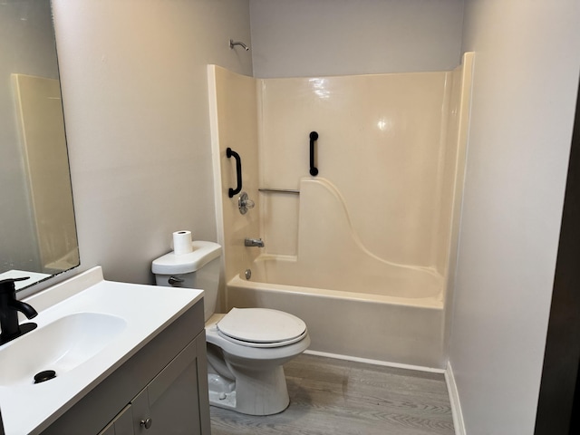 bathroom featuring wood finished floors, toilet, washtub / shower combination, and vanity