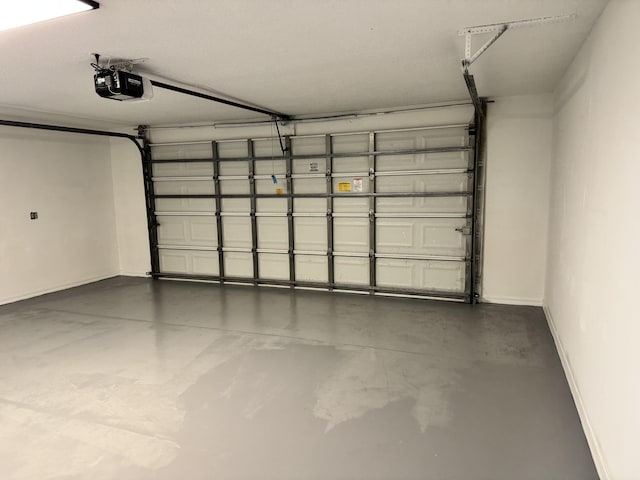 garage with a garage door opener and baseboards