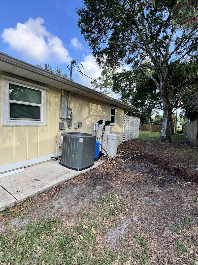 back of property with fence and central AC