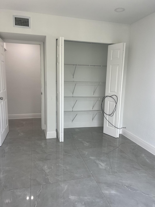 410 S D St, Lake Worth Beach, FL 33460 - unfurnished bedroom featuring a closet, marble finish floor, visible vents, and baseboards
