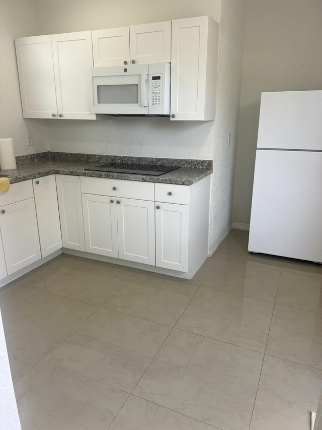 410 S D St, Lake Worth Beach, FL 33460 - kitchen featuring baseboards, white appliances, white cabinets, and dark countertops