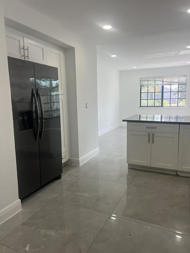 410 S D St, Lake Worth Beach, FL 33460 - kitchen with white cabinets, refrigerator with ice dispenser, baseboards, and marble finish floor