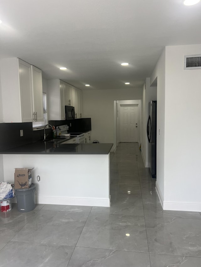 410 S D St, Lake Worth Beach, FL 33460 - kitchen with a peninsula, dark countertops, visible vents, and black appliances