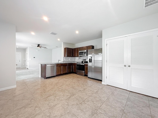 kitchen with dark brown cabinetry, visible vents, stainless steel appliances, and a sink