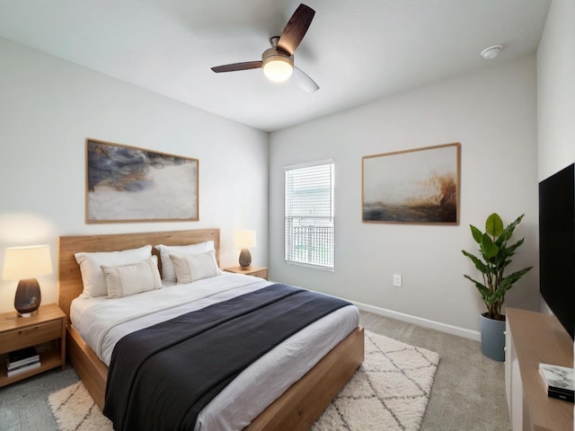 bedroom with light carpet, ceiling fan, and baseboards