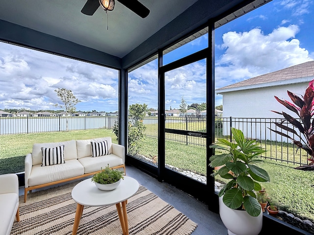 sunroom / solarium featuring a water view and ceiling fan