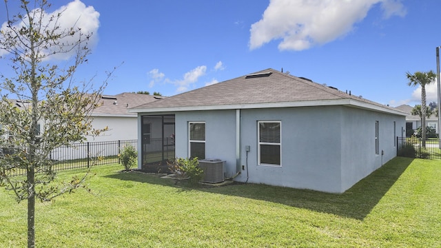 rear view of house featuring a yard, cooling unit, a fenced backyard, and stucco siding