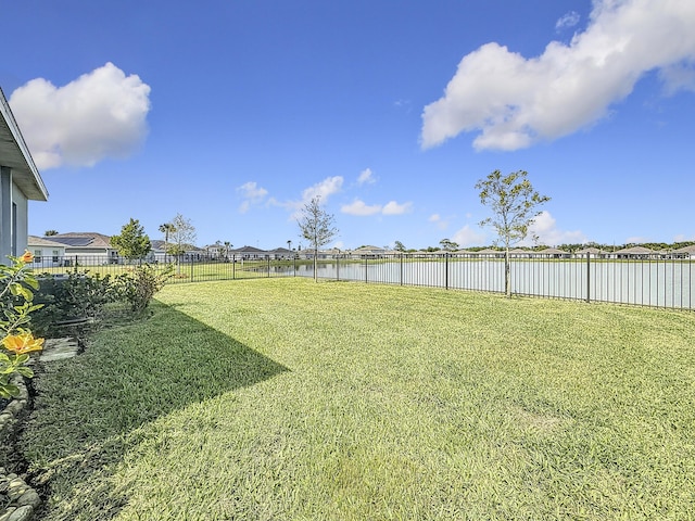 view of yard featuring a water view and a fenced backyard