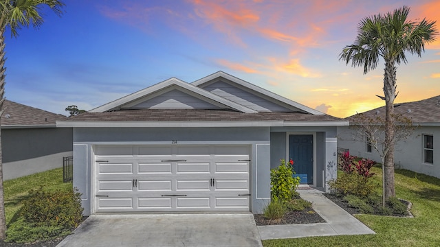 single story home featuring concrete driveway, roof with shingles, an attached garage, a front lawn, and stucco siding